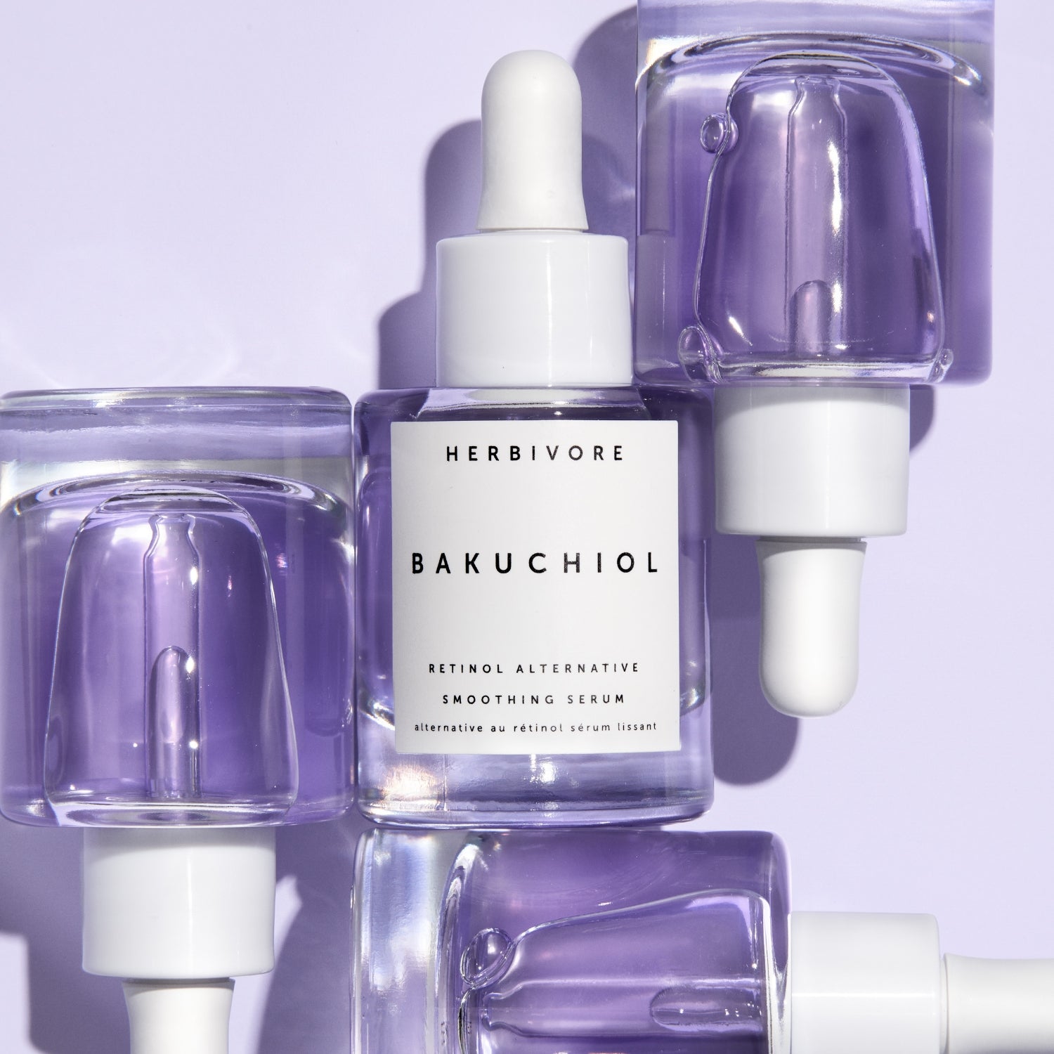 Close-up of multiple clear Bakuchiol Retinol Alternative Smoothing Serums with purple serum visible
