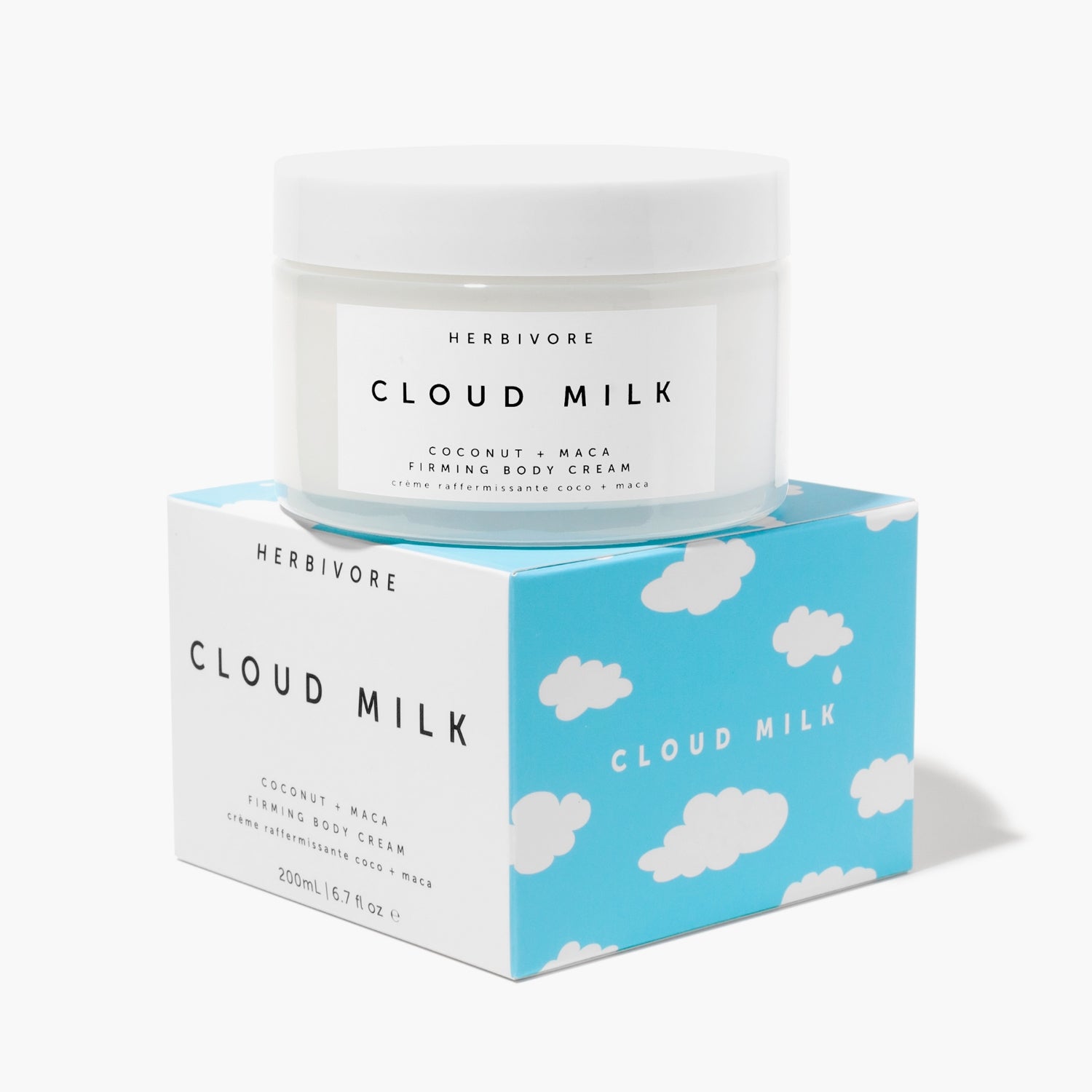 Jar of Cloud Milk FIrming Body Cream on top of its white + blue cloud-printed outer box